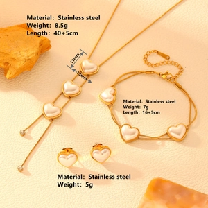 Golden stainless steel jewelry set with heart pearl pendants and crystal tassel details