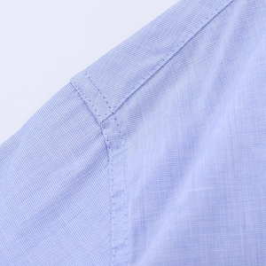 Vista macro dettagliata del tessuto azzurro e della cucitura sulla spalla della camicia