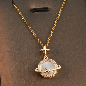 Elegant gold celestial planet necklace with pearl pendant and star details on dark card