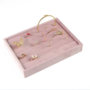 Detailed view of pink velvet jewelry display tray organized with rings and bracelets