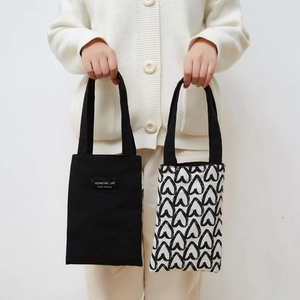 Detail view of canvas tote bag showing the Geometric Life fabric label and texture