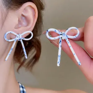 Boucles d'oreilles nœud élégantes avec texture marbrée bleue et blanche en résine