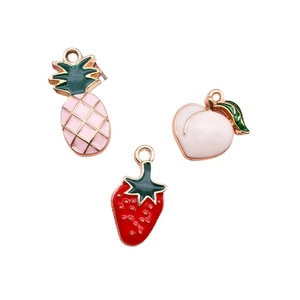 Detailed view of enamel fruit charms including pink pineapple, strawberry, and peach pendants