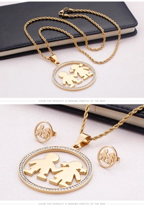 Détail du collier doré et des clous d'oreilles avec silhouettes d'enfants et strass