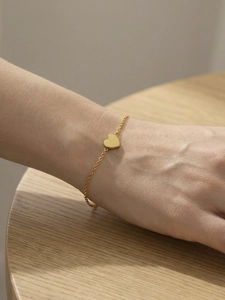 Detailed view of a polished heart pendant on a minimalist gold stainless steel chain