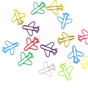 Close-up of fourteen colorful airplane shaped metal paper clips on a white background