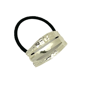 Elastic black ponytail holder featuring a textured silver hammer-finish metal sleeve accent
