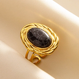Macro shot of an adjustable gold stainless steel ring with a black marbled stone oval