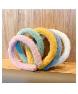 Colorful plush headbands in pink green yellow blue and white on wooden background