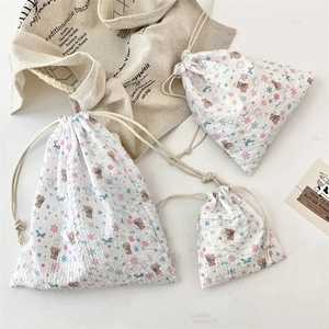 Three sizes of floral bear drawstring pouches on white marble with aesthetic lifestyle props