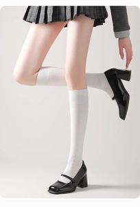 Gros plan de chaussettes montantes blanches en coton avec des chaussures Mary Jane