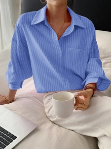 Detail of blue striped long sleeve shirt with classic collar and front pocket