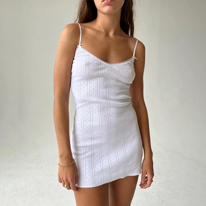 Detail shot of the white mini dress showing the textured fabric and lace V-neckline
