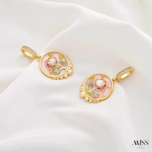 Detail of gold oval pendants with pink enamel flowers and pearls on white silk