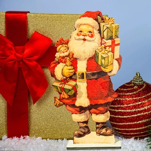 Macro detail of vintage wooden Santa Claus figurine with gifts on snowy festive background