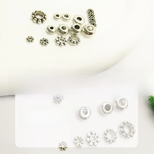 Détail macro de diverses entretoises et perles flocon argentées pour bijoux DIY