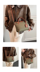 Close-up of olive green nylon tote with leather handles and detachable shoulder strap