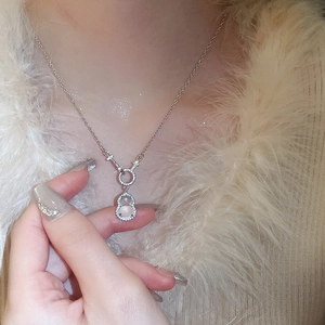 Close-up of silver gourd necklace pendant with pink gemstone and small rhinestones