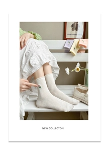 Close-up of floral embroidery on cream cotton mid-calf socks with macaron color variety