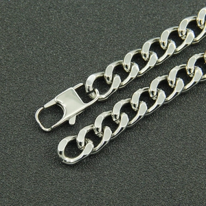 Polished silver stainless steel Cuban link bracelet with spring clasp on dark background