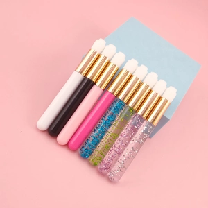 Detail of eight eyelash extension cleansing brushes in various colors on a blue cube