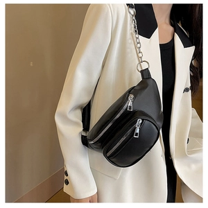 Gros plan d'un sac de poitrine en cuir PU noir avec chaîne argentée et doubles fermetures