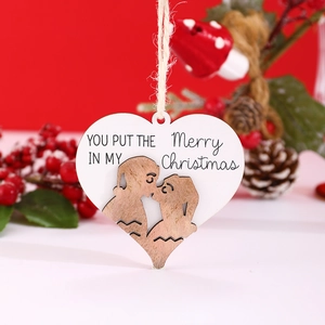 Close-up of heart-shaped wooden Christmas tag with festive text and rustic rope