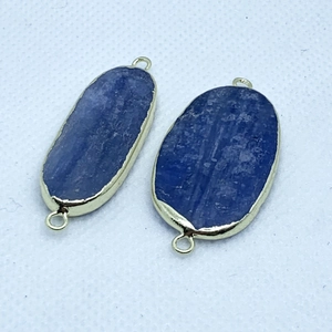 Close-up of oval blue natural stone pendants with gold plated edges for DIY jewelry making