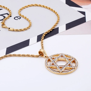 Macro detail of a gold David Star pendant with rhinestones on a thick twisted chain