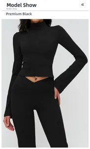 Detail of premium black yoga jacket with stand collar and V-shaped crossover high waist leggings