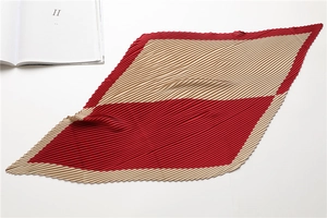 Detail of red and beige color-block pleated scarf with fine geometric accordion texture