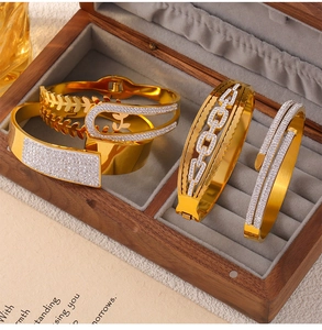 Vue détaillée de bracelets en titane doré avec zircons dans un écrin à bijoux chic