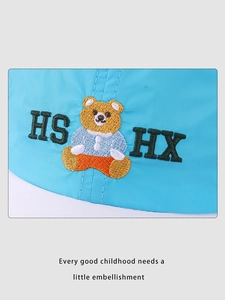 Detail of blue quick-dry cap showing a cute bear embroidery with green letter accents