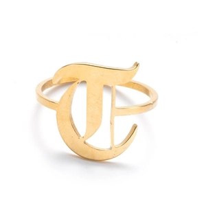 Detailed close-up of golden gothic letter T engraved on a vintage stainless steel ring