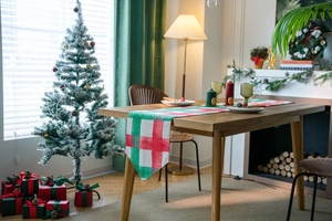 Detail of red and green Christmas plaid table runner in a cozy festive holiday home setting