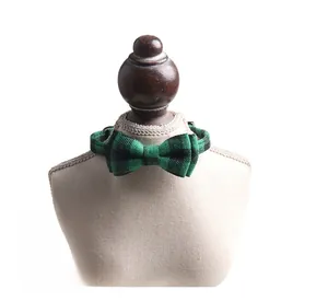 Detail of green and black plaid cat collar with bowtie and plastic buckle on display