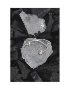 Macro detail of S925 sterling silver irregular horseshoe ring on crystal and charcoal