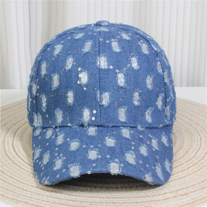 Close-up of distressed blue denim baseball cap with sparkling silver sequins