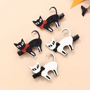 Detail view of four glitter cat hair clips in black and white with festive bows