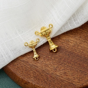 Golden chalice religious connector pendants with IHS engraving on wooden base