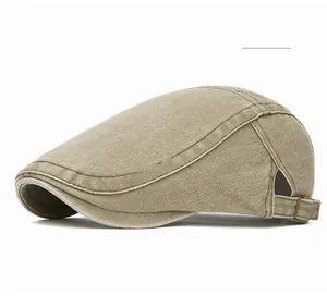 Detail of light khaki flat cap featuring washed cotton texture and adjustable brass buckle