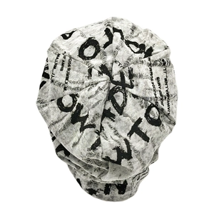 Detail of distressed grey knit beanie featuring black letter prints and graffiti style