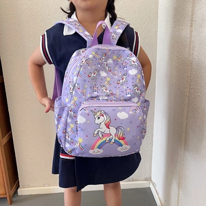 Cute purple toddler backpack with unicorn and rainbow print worn by a child