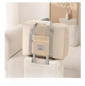Beige quilted travel bag with back trolley sleeve shown on white luggage suitcase