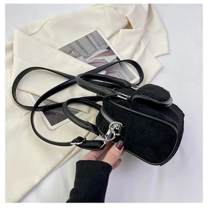 Detailed close-up of a black faux suede mini tote bag with PU leather straps and silver hardware
