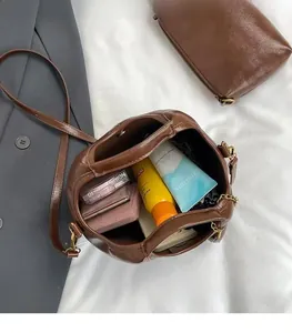 Detail shot of vintage brown leather tote showing spacious interior and chain accent