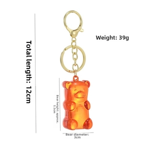 Detail showing an orange resin jelly bear keychain with dimensions 12cm length and 39g weight