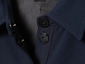 Macro detail of dark blue dress with black metal snap buttons and twill fabric texture
