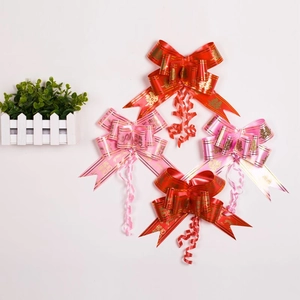 Detail of red and pink Chinese wedding pull bows with gold Double Happiness symbols