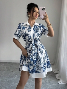 Detail of floral printed dress with button-down front, lapel collar, and waist tie belt